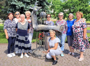 Grupė keliautojų prie Zarasų simbolio Elniažuvės skulptūros.