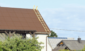 Paramos lėšomis kompensuojamos išlaidos stogo dangai ir statybinėms medžiagoms, būtinoms stogo dangai pakeisti. Dariaus Šypalio nuotr.