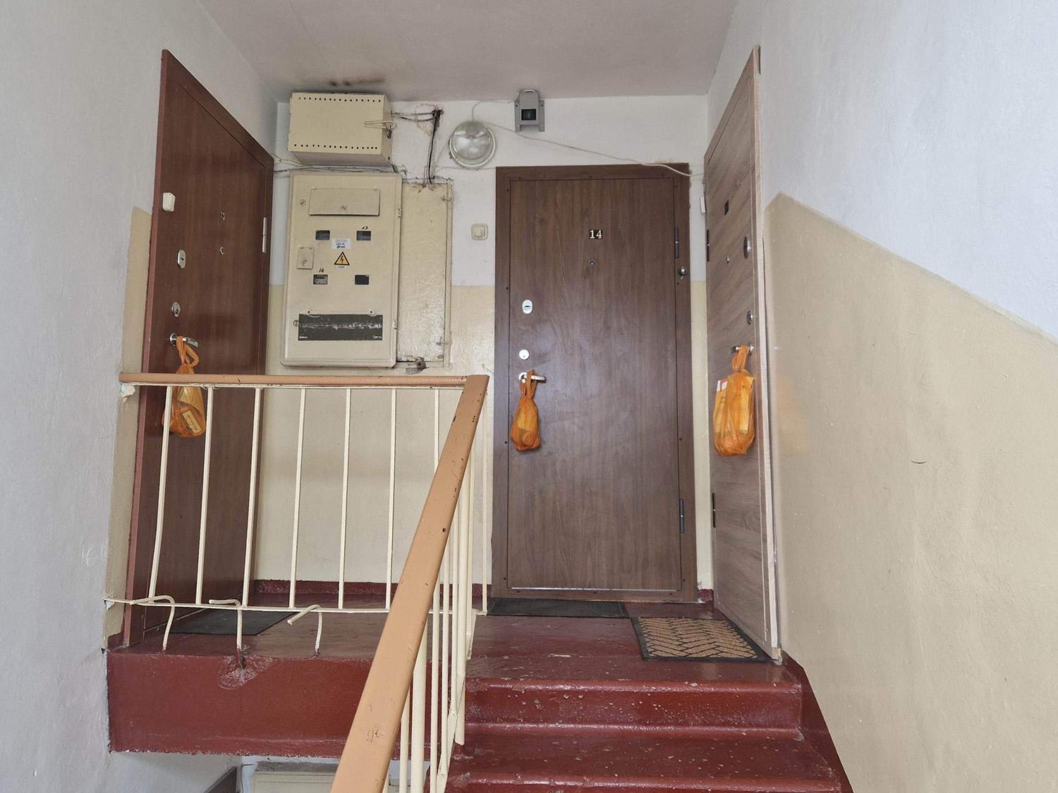 Maišelius maisto atliekoms rūšiuoti išdalino moksleiviai / Ant butų durų – oranžiniai maišeliai.