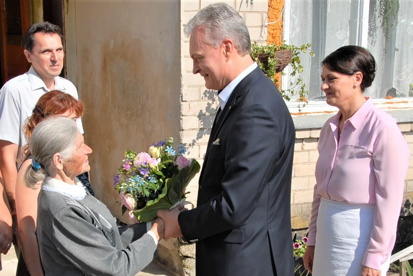 Pabaisko bažnyčios prižiūrėtoją pasveikino šalies vadovas / Gedimino Nemunaičio nuotr. Prezidentas Gitanas Nausėda pasitiktas prie jubiliatės namų laiptinės.