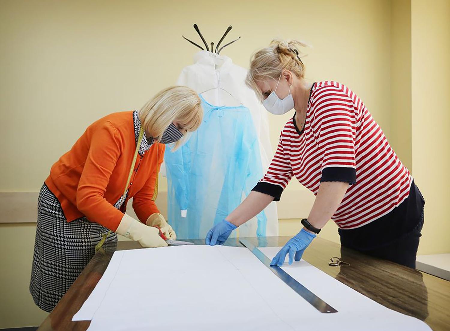 Siuva vienkartinius kombinezonus medikams / Kultūros centro darbuotojos karantino metu kerpa