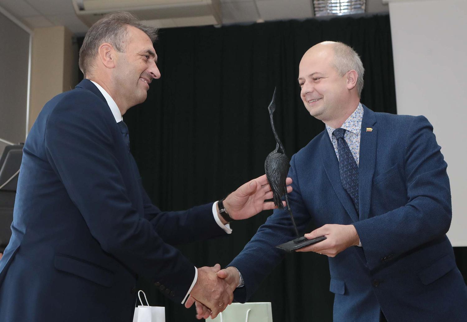 Su jubiliejumi pasveikinti atvyko ir ministras / Dainiaus Vyto nuotr. Aplinkos ministras Simonas Gentvilas „Ukmergės vandenų“ direktoriui Rimui Arlinskui padovanojo gervę.