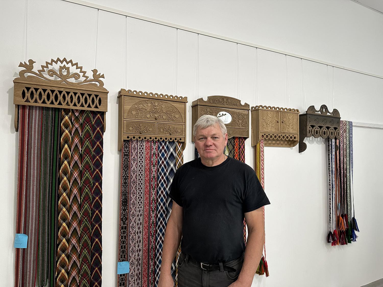 Tautodailės parodoje – nuo juostų iki kryžių / Autorės nuotr. S. Zinkevičiaus drožinėtose rankšluostinėse sukabintos tautinės juostos.