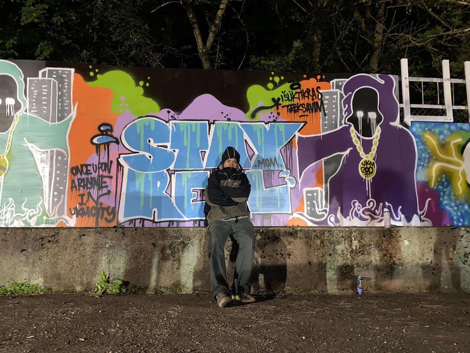 Ukmergėje įkurta legali grafičių siena / Gertrūdos Statkutės nuotr. Grafičių siena pasipuošė skirtingų menininkų darbais. Prie savo grafičio – L. Šlinkšė.